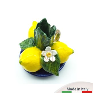 Bugia formata da 3 limoni con foglie e fiorellini adagiata su un piattino limoges.