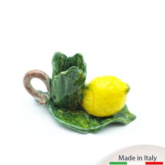Portacandela con un limone piccolo adagiato su foglia e manico.